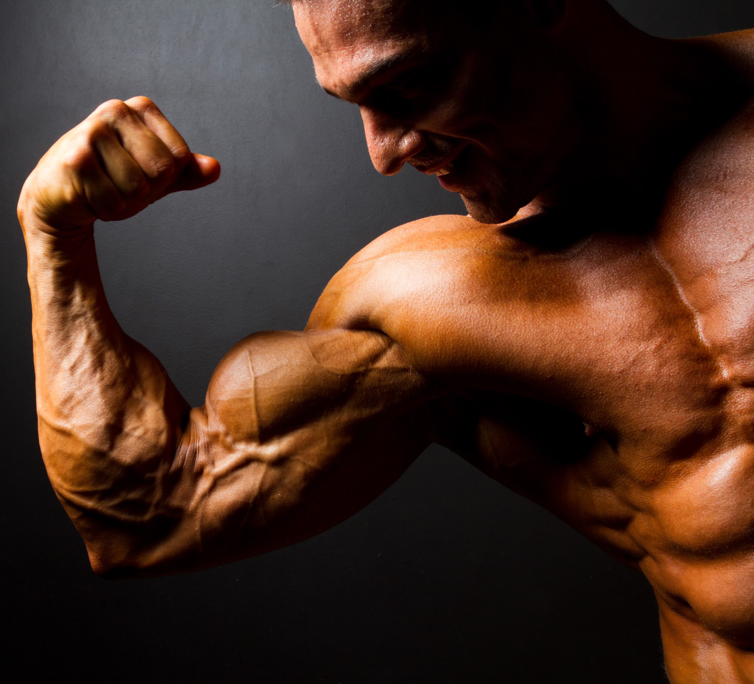 strong bodybuilder posing on black background